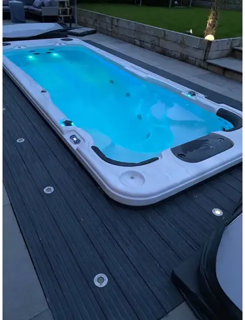 PassionSpa Aquatic 2 Swim-Spa – weiße Ausführung, rechteckige Form, blaue Beleuchtung, blaues Wasser, schwarze Akzente