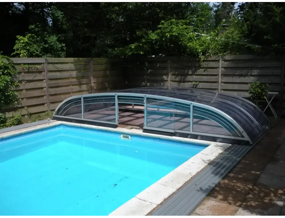 Pooltak Nivo Kit i transparent glas med metallram över blå pool