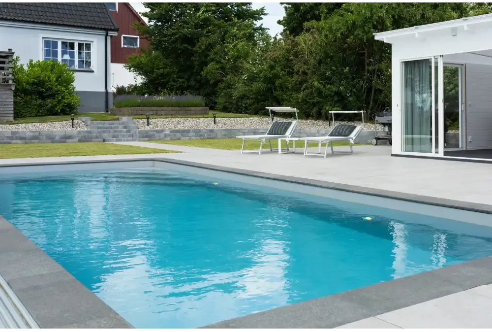 Pooltime Exklusiv 12mm rektangulär pool med klart blått vatten och grå betongkanter