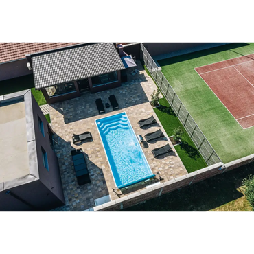 Blå rektangulär glasfiberpool Aruba med kaklade kanter och vattenrullningar