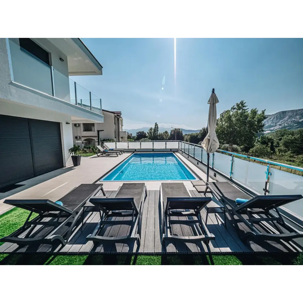 Rektangulär blå glasfiberpool Aruba med glasräcke och klart vatten