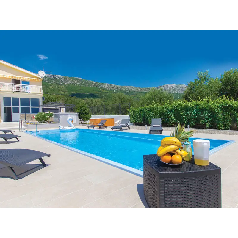 Svart rottingbord med flätad textur, bananer, apelsiner och gul vätska för Jamaika 25x3 75x1 50m