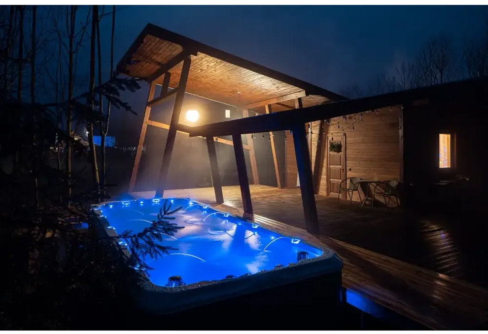 PassionSpa Activity 2 Swim-Spa – blaue Beleuchtung, Holzterrasse, überdachte Terrasse