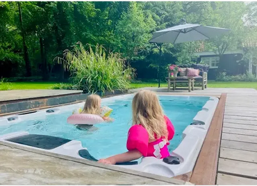 PassionSpa Aquatic 1 Swim-Spa – weiße Ausführung, Kinder im Whirlpool, Holzterrasse