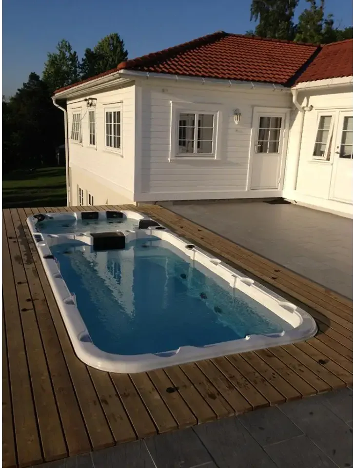 PassionSpa Aquatic 3 Swim-Spa – weiße Ausführung, rechteckige Form, blaues Wasser, schwarze Sitzpolster, Holzterrasse
