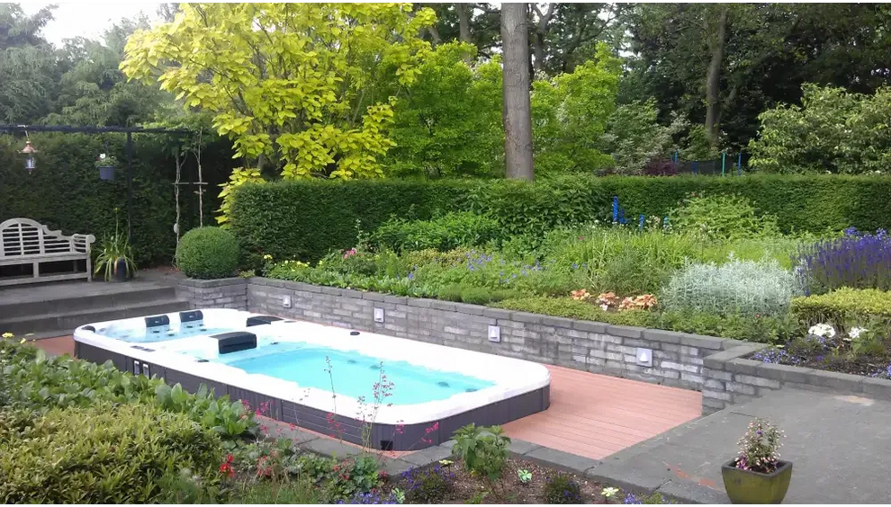 PassionSpa Aquatic 3 Swim-Spa – weißer Innenraum, dunkelgraue Oberfläche, Holzterrasse, umgebendes Grün