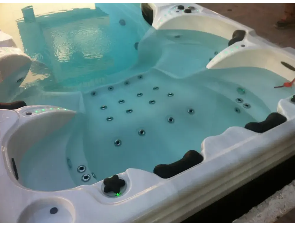 PassionSpa Aquatic 6 Swim-Spa – weiße Ausführung, weißer Innenraum, schwarze Sterngriffe, blaues Wasser