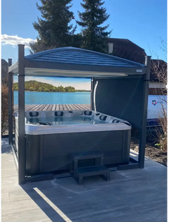 PassionSpa Devotion Whirlpool – Signature Collection, dunkelgraue Oberfläche, Dach, Treppe, unter blauem Himmel