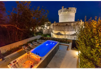 PassionSpa Dynamic Swim-Spa – blaue Beleuchtung, orangefarbener Innenraum, bei Nacht, steinerner Burgturm