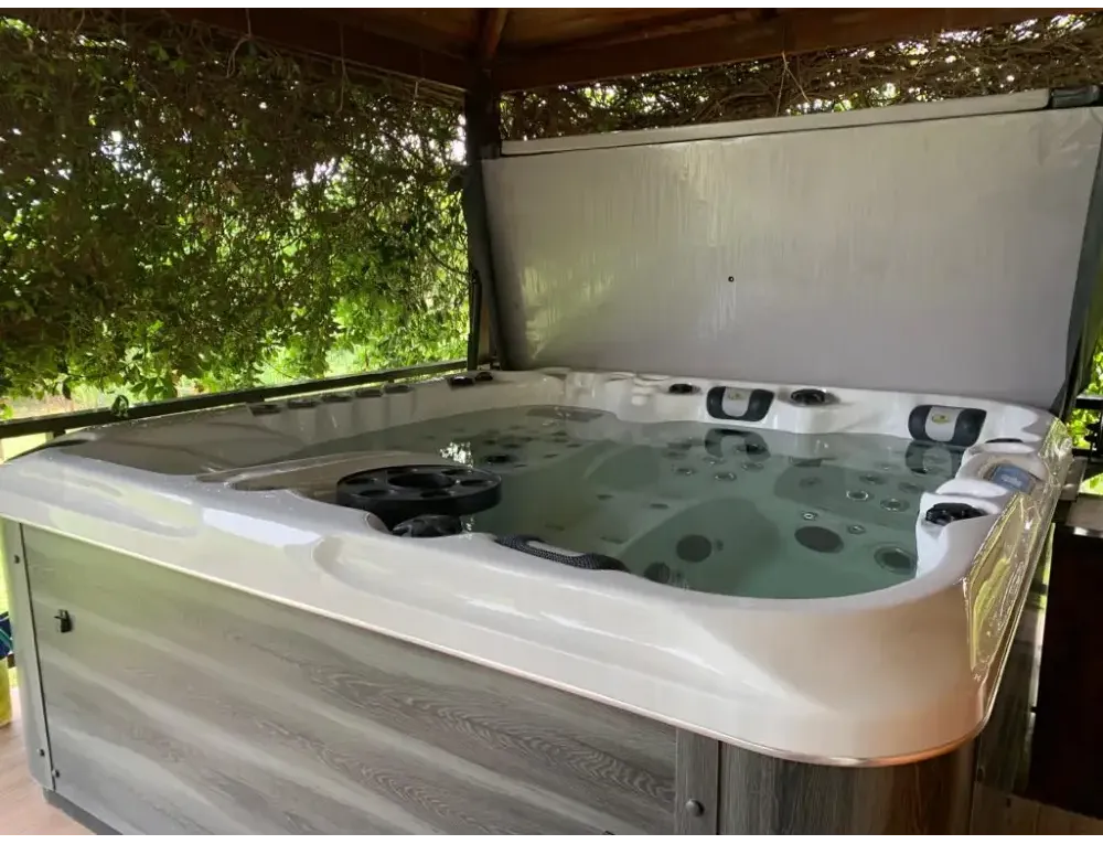 PassionSpa Euphoria Mighty Wave Whirlpool – weiße Ausführung, weißer Innenraum, graue Holzpaneele, schwarze Massagedüsen