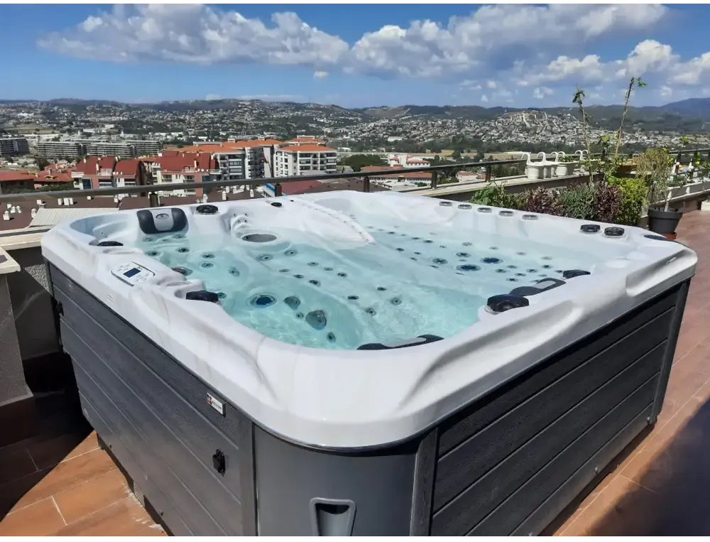 PassionSpa Euphoria Mighty Wave Whirlpool – weiß und grau, schwarze Massagedüsen, klares blaues Wasser