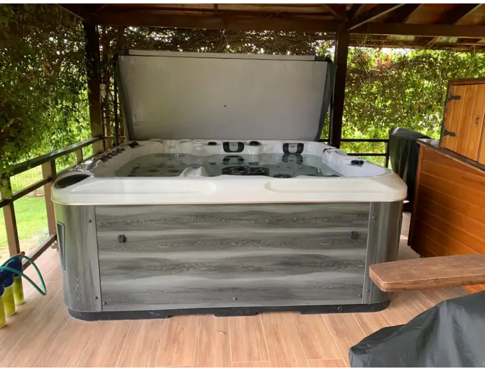 PassionSpa Euphoria Mighty Wave Whirlpool – graue Oberfläche in Holzoptik, weißer Innenraum, schwarze Massagedüsen