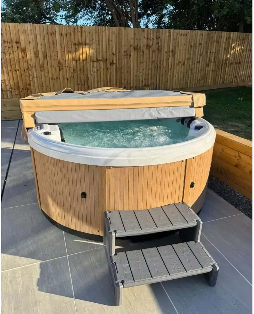 PassionSpa Recharge Whirlpool – Holzpaneel, graue Stoffabdeckung, sprudelndes Wasser, türkisfarbenes Wasser