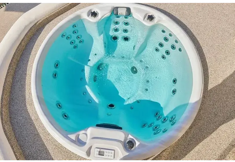 PassionSpa Recharge Whirlpool – Pure Collection, weiße Ausführung, türkisfarbenes Wasser, schwarze Massagedüsen