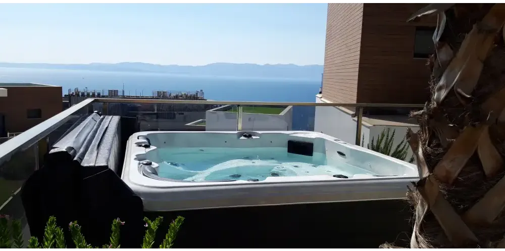 PassionSpa Relax Whirlpool – Pure Collection, weiße Ausführung, rechteckige Form, blaues Wasser, schwarze Paneele