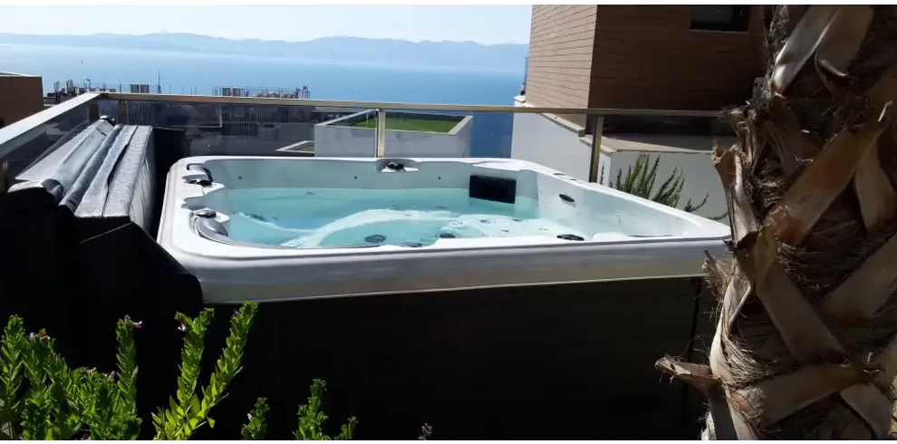 PassionSpa Relax Whirlpool – Pure Collection, weiße Ausführung, auf einem Balkon, Meerblick