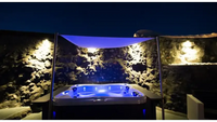 PassionSpa Renew Whirlpool – Pure Collection, blaue Beleuchtung, weiße Ausführung, unter einem Dach, bei Nacht