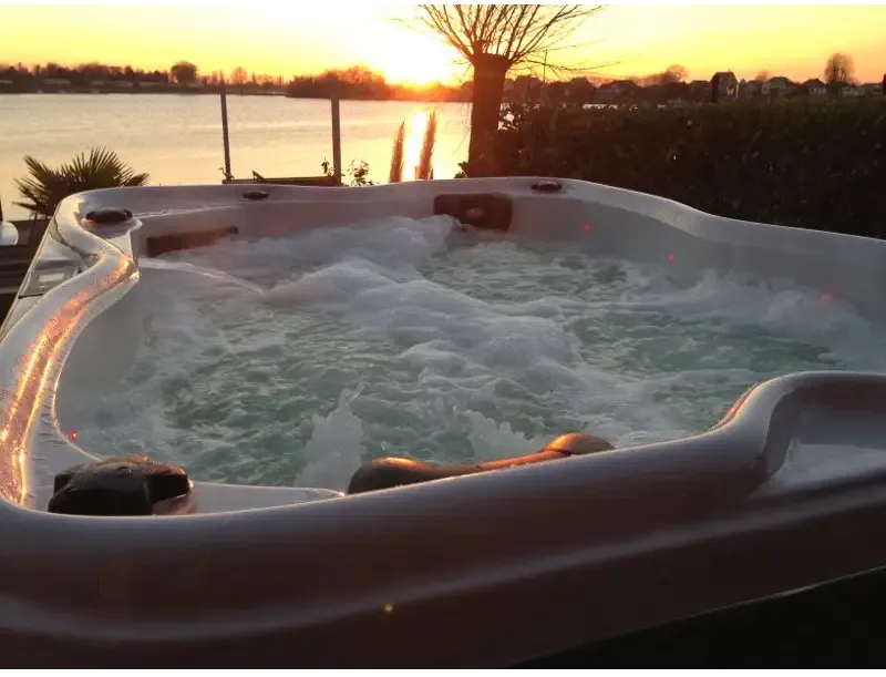 PassionSpa Renew Whirlpool – weiße Ausführung, rote LED-Beleuchtung, Sonnenuntergang über einem See