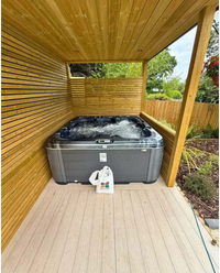 PassionSpa Rewind Whirlpool – graue Ausführung, schwarzer Innenraum, sprudelndes Wasser, Holzterrasse
