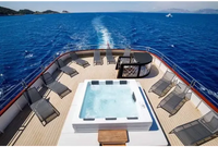 PassionSpa Serene 6 Whirlpool – weiße Ausführung, Feuerstelle, rechteckige Form, klares blaues Wasser, schwarzer Rand, auf einem Bootsdeck