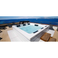 PassionSpa Serene 6 Whirlpool – weiße Ausführung, rechteckige Form, schwarze Paneele, klares blaues Wasser, Holzterrasse