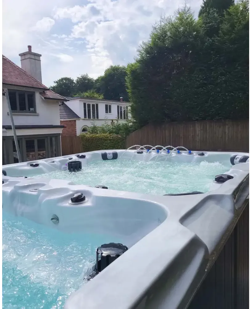 PassionSpa Vitality Swim-Spa – stilvolles Design, hellgraue Oberfläche, sprudelndes Wasser, türkisfarbenes Wasser, schwarze Massagedüsen