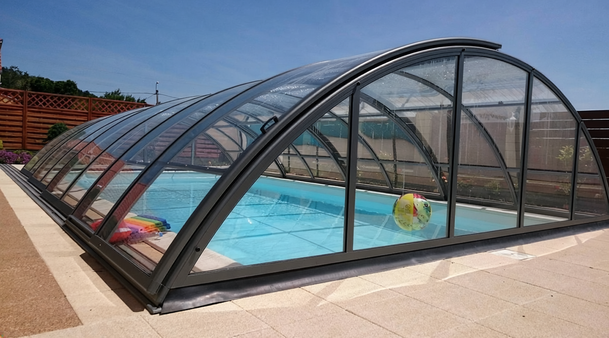 Classic Poolüberdachung mit klaren Polycarbonatflächen und anthrazitfarbenen Profilen – Umgebungsbild der Modellreihe.