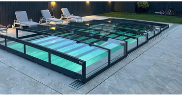 Modern glasinkapslad inomhuspool med Pooltak Icon Kit, svart ram och turkost upplyst vatten
