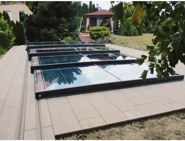 Moderne Mästare Plus Poolüberdachung – transparente Paneele, schwarzer Rahmen, über einer gefliesten Terrasse