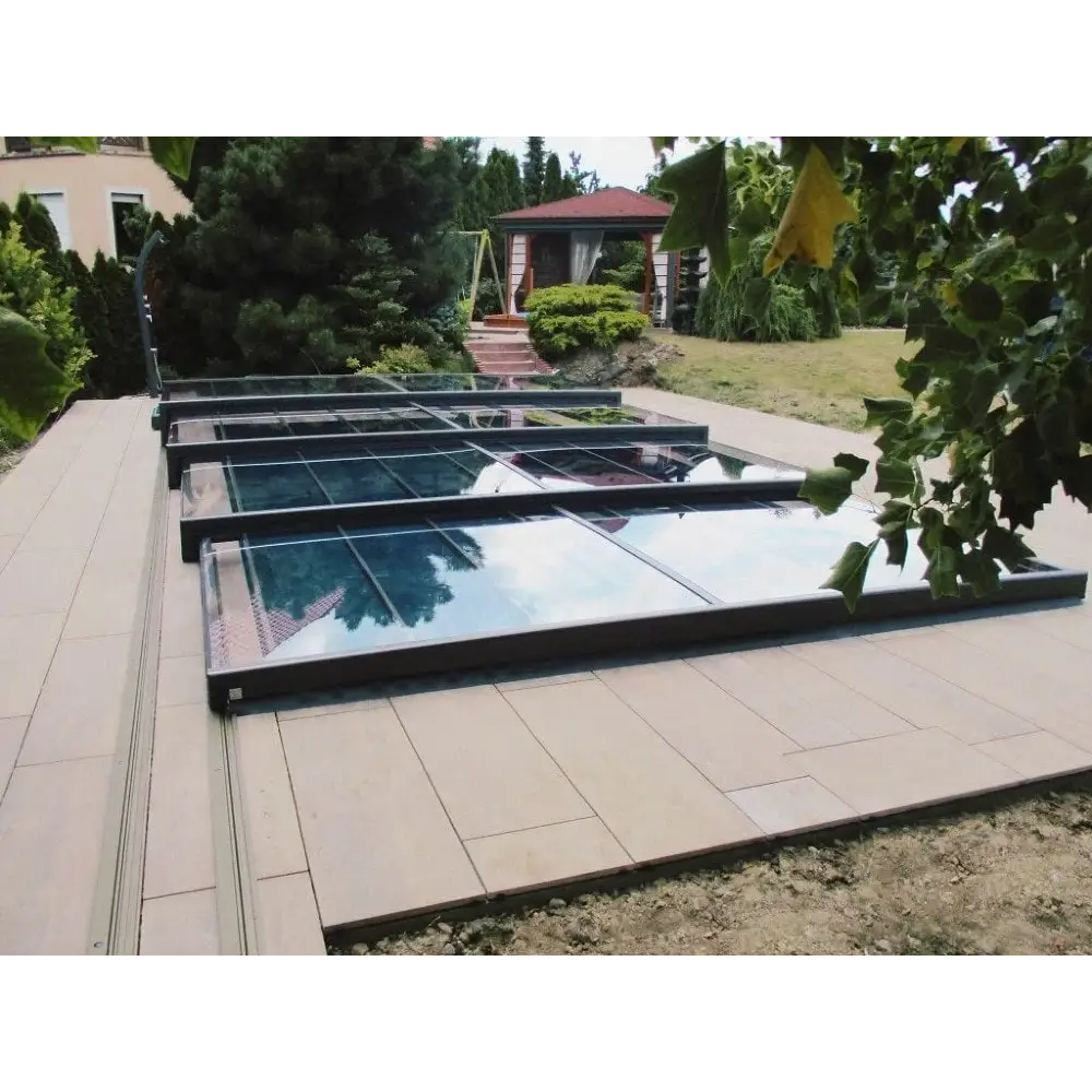 Pooltak Mästare Plus med modern glasdesign och svart ram över kaklat uteplats