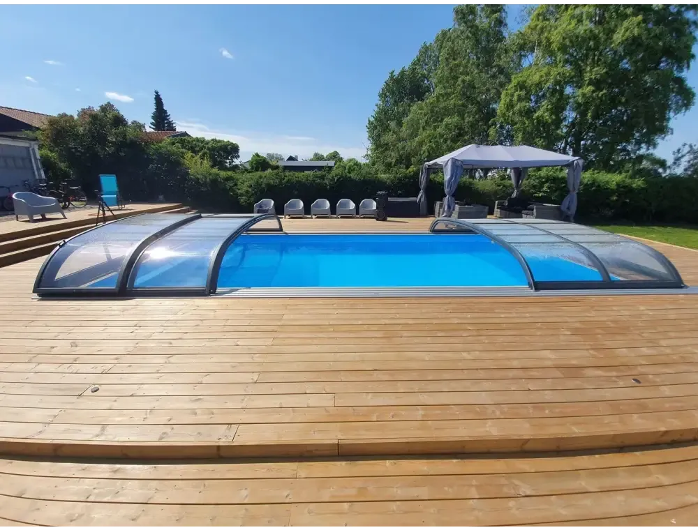 Blå pool med transparent böjd pooltak Nivo Kit 650B på trädäck
