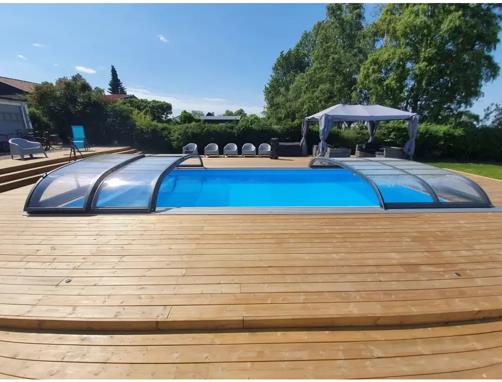Blå pool med transparent böjd pooltak Nivo Kit 650B på trädäck