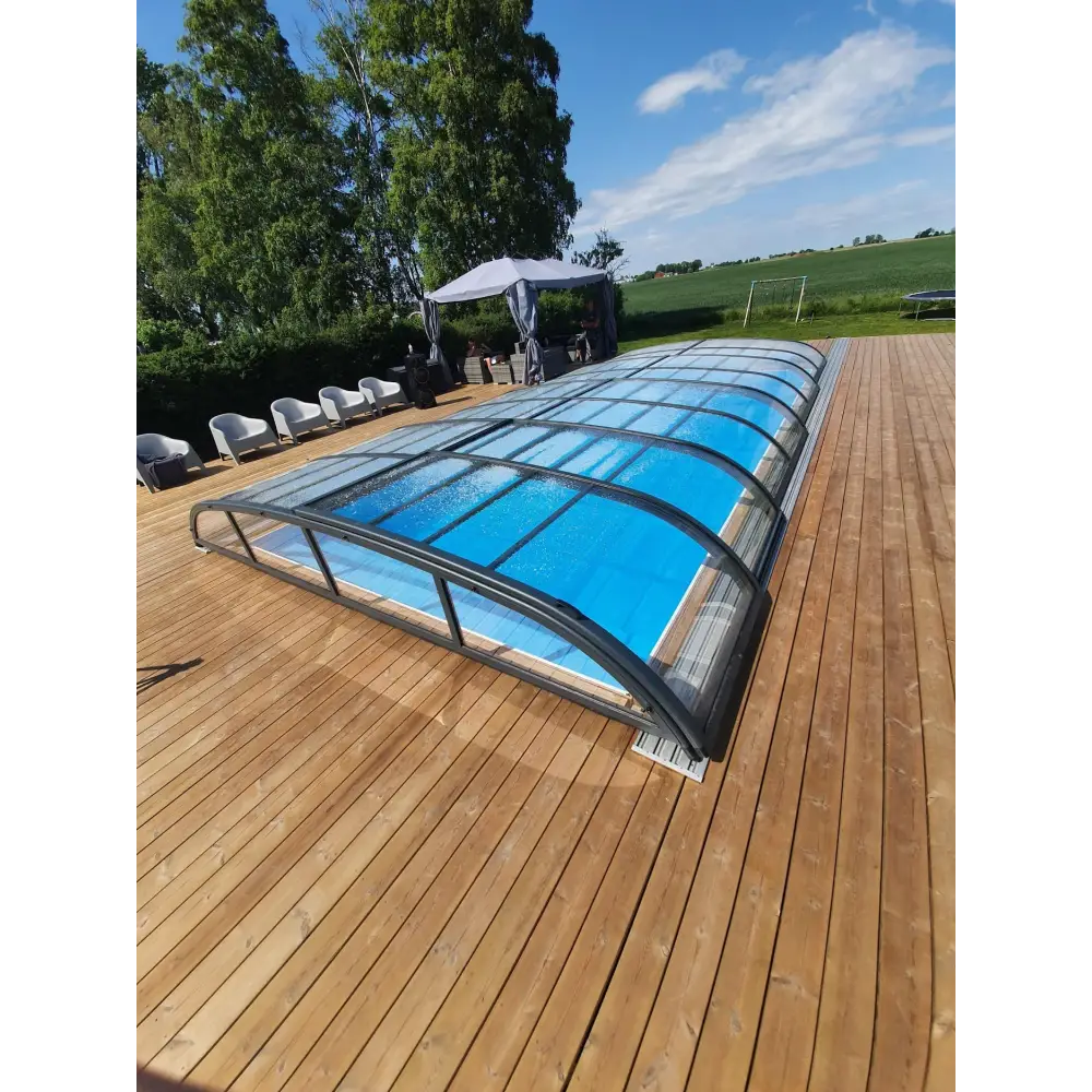 Pooltak Nivo Kit 860B med blå pool, kurvad glasöverdel och svart ram på trädeck