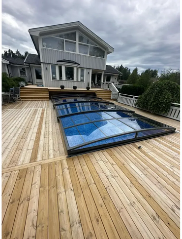 Ultraflache Poolüberdachung – elegantes Design, dunkle Rahmen, über einem blauen Pool, Holzterrasse