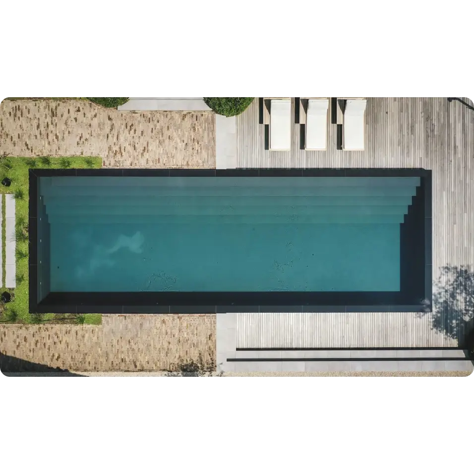 Exklusiv infinity pool med turkost vatten och svart kakel från Pooltime